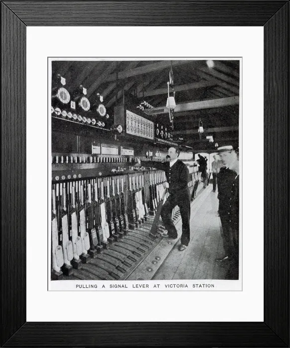 Framed Print : Photograph showing the signalman in the act of pulling a signal lever to allow a train to enter one of the platforms. Date: 1907
