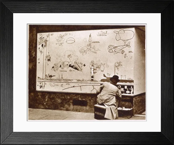Framed Print : Artist Norman Keene replicating the original drawings done by William Heath Robinson on boarded up shop fronts in London. Heath Robinson designed pictures to illustrate the particular merchandise inside the shop Framed Print : Artist Norman Keene replicating the original drawings done by William Heath Robinson on boarded up shop fronts in London. Heath Robinson designed pictures to illustrate the particular merchandise inside the shop