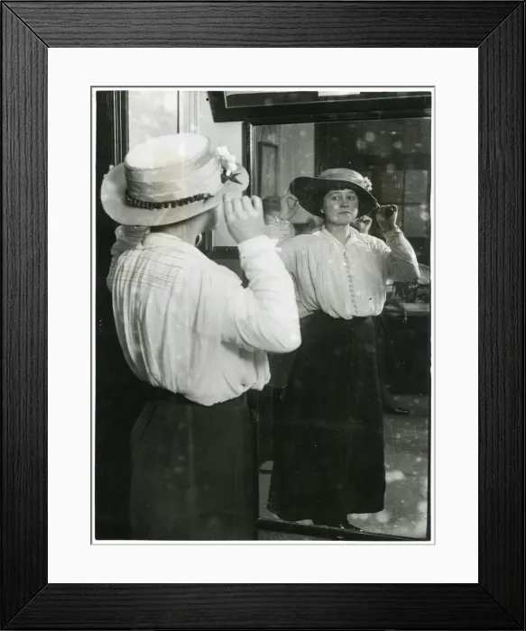 Framed Print : Woman examining her hat in a mirror Framed Print : Woman examining her hat in a mirror