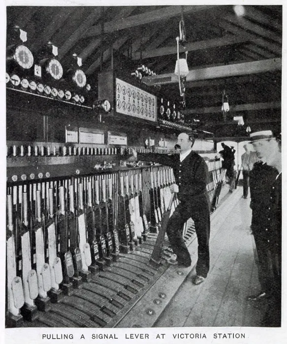 Framed Print : Photograph showing the signalman in the act of pulling a signal lever to allow a train to enter one of the platforms. Date: 1907
