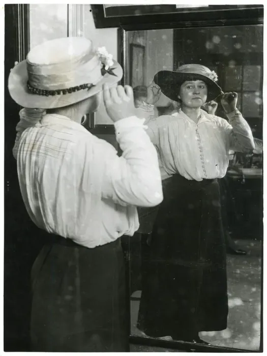 Framed Print : Woman examining her hat in a mirror Framed Print : Woman examining her hat in a mirror