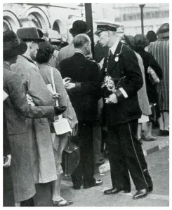 Public Prints: Bus conductor collecting fares from queuers, September 1939
