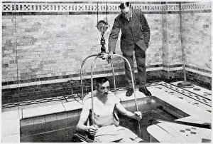 20th Prints: A man been lowered by crain into a bath of hundreds of gallon of radio-active water