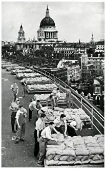 Building Prints: Outbreak of WWII Sandbagging flat roof of an office building