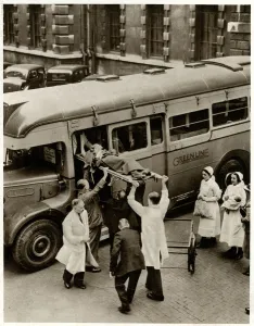 Hospital Prints: Patient on stretcher lifted onto evacuation coach 1939
