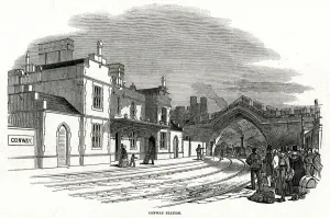Wales Prints: Train passing under arch into Conway railway station 1848