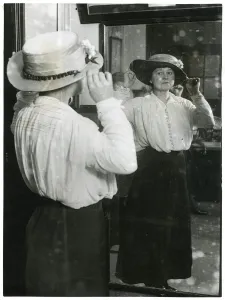 University Prints: Woman examining her hat in a mirror